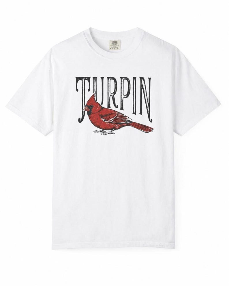 A plain white short-sleeve t-shirt featuring a red cardinal illustration and the black text Turpin on a white background.