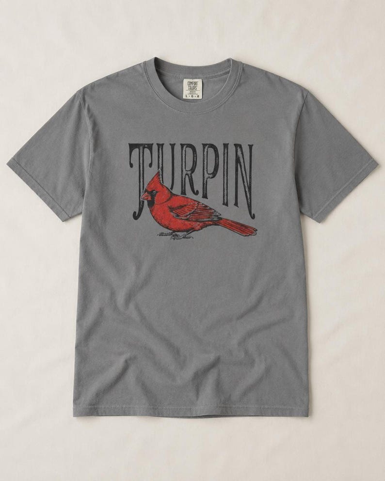 A slate gray short-sleeve t-shirt featuring a red cardinal and black vintage Turpin text centered on the chest.