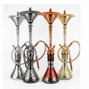 Puede incluir: Cuatro narguiles ornamentados en plata, negro, cobre y oro. Cada narguile presenta un tallo decorativo, una base de vidrio y una manguera. Los narguiles están dispuestos sobre un fondo blanco, mostrando sus intrincados diseños.