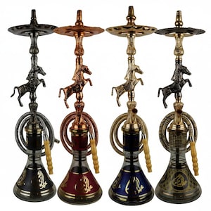 Puede incluir: Cuatro narguiles decorativos en negro, cobre, dorado y bronce. Cada uno presenta un acento en forma de caballo y una base de vidrio decorativa con detalles dorados. Los narguiles tienen mangueras enrolladas y boquillas de madera.