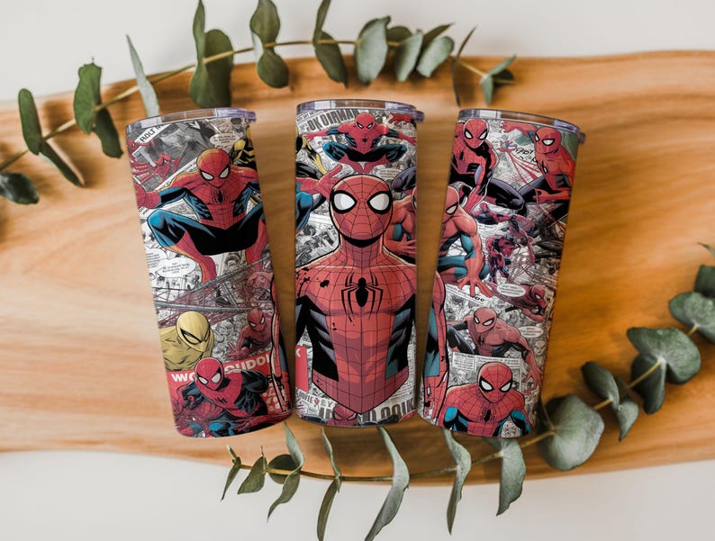 K&ouml;nnte beinhalten: Drei Edelstahlbecher mit einem Spider-Man-Comic-Design. Die Becher sind zylindrisch, mit einem transparenten Deckel und einem umlaufenden Aufdruck von Spider-Man in verschiedenen Actionposen, vor dem Hintergrund von Comic-Panels. Das Farbschema ist haupts&auml;chlich rot, blau und schwarz.