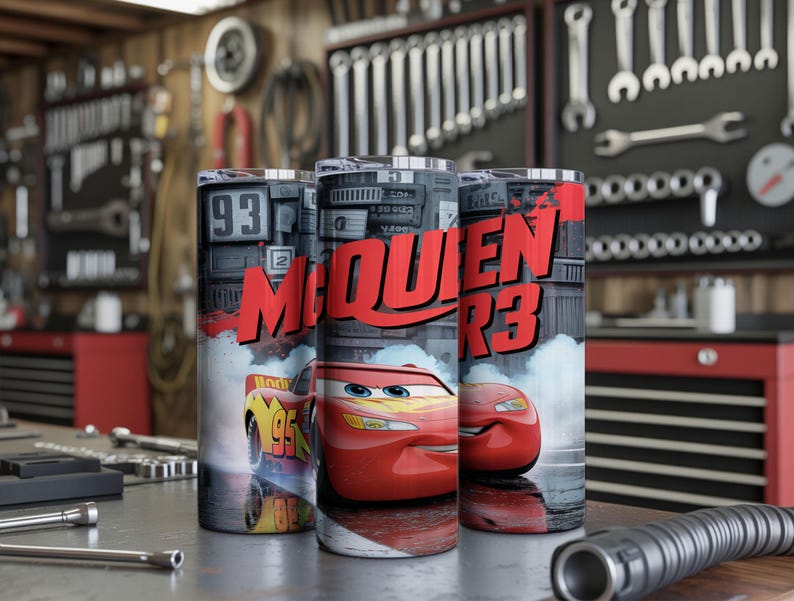 Pu&ograve; includere: Tre bicchieri cilindrici con la grafica dell'auto da corsa rossa Lightning McQueen. Il design include il testo "MCQUEEN" in grassetto rosso, il numero 95 e uno sfondo che raffigura un garage con attrezzi e componenti meccanici.
