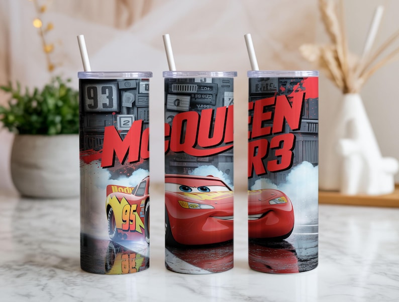 Pu&ograve; includere: Tre bicchieri cilindrici con cannucce bianche che presentano una grafica di auto da corsa rossa, il numero 95 e il testo McQueen R3. Il design include uno sfondo grigio scuro con dettagli meccanici ed effetti di fumo.