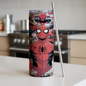 K&ouml;nnte beinhalten: Ein Edelstahlbecher mit einem Spider-Man-Design. Der Becher zeigt den Superhelden in seinem ikonischen rot-schwarzen Anzug mit einem Spinnenemblem. Ein silberner Strohhalm ist enthalten.