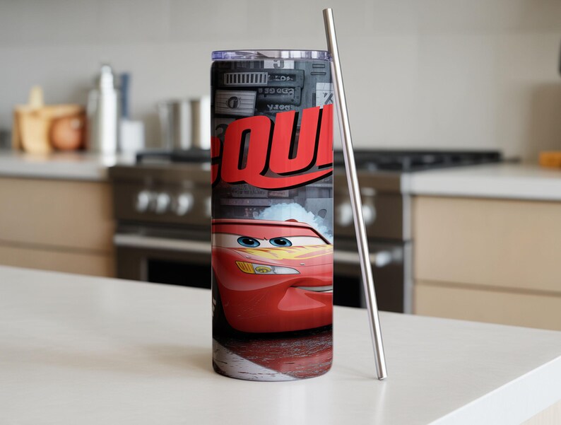 Pu&ograve; includere: Un bicchiere cilindrico in metallo con la grafica di un'auto da corsa rossa con occhi blu e decalcomanie a forma di fulmine giallo. Il design include il testo rosso parziale "QU" su sfondo grigio ed &egrave; dotato di una cannuccia in metallo sottile.