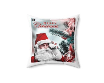 Puede incluir: Cojín cuadrado blanco con un diseño navideño. El cojín presenta a Papá Noel guiñando un ojo, vestido con un gorro y traje rojos, con las palabras "MERRY Christmas" en escritura roja. Un árbol de Navidad con adornos está en el fondo.
