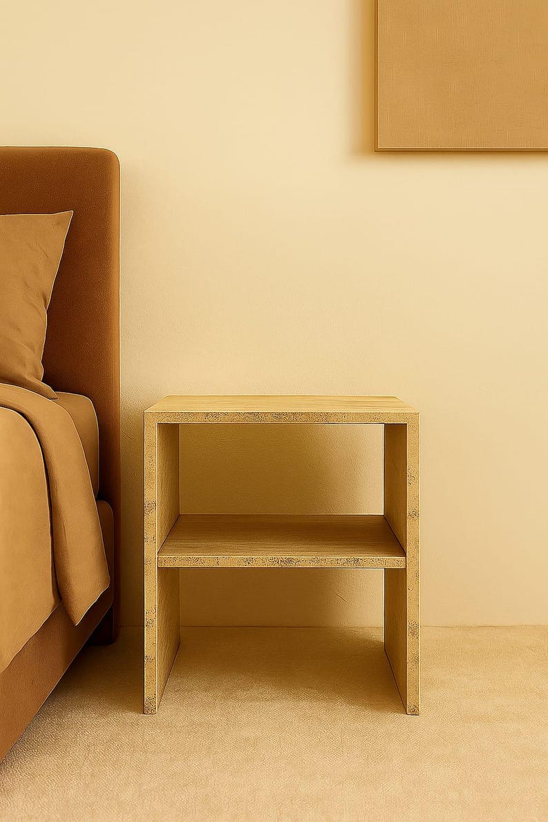 May include: A light-colored, two-tiered wooden nightstand with a rectangular frame. The nightstand is placed next to a bed with a brown headboard and bedding. The background is a solid, light-yellow color.