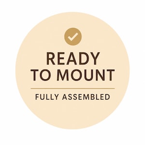 May include: A circular beige sticker with the text "READY TO MOUNT" in dark brown, with a checkmark icon above the text. Below the text is the phrase "FULLY ASSEMBLED".