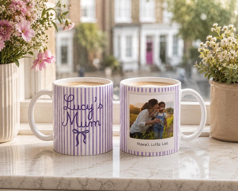 Peut inclure: Deux mugs en c&eacute;ramique blanche avec du caf&eacute;, pr&eacute;sentant un motif &agrave; rayures violettes. L'un des mugs porte l'inscription "Lucy's Mum" avec un n&oelig;ud, l'autre une photo et le texte "Mama's Little Love". Les mugs sont sur un rebord de fen&ecirc;tre.
