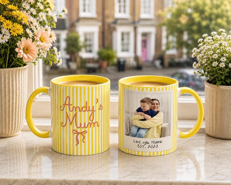 Peut inclure: Deux mugs jaunes &agrave; rayures verticales. L'un porte l'inscription "Andy's Mum" en rose. L'autre mug pr&eacute;sente une photo d'une m&egrave;re et d'un enfant avec le texte "Love you Mama EST. 2023".
