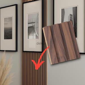 May include: A rectangular sample of dark brown wood-look wall paneling with three vertical slats, shown against a wall featuring matching vertical wood slat paneling, black-framed wall art, and a small black wall-mounted light fixture.