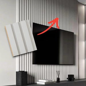 May include: A white wall panel featuring a series of vertical, parallel grooves and a flat, light-colored surface. The panel is shown as a sample piece next to a wall covered in identical vertical slats, with a black television mounted on the wall.
