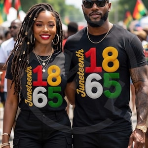 May include: Two people wearing black t-shirts with the text "Juneteenth 1865" in red, yellow, green, and white. The shirts are paired with black shorts. The background shows a crowd and colorful flags.