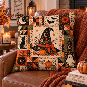 May include: A square throw pillow featuring a patchwork design with Halloween-themed illustrations including a witch hat, black cat, ghosts, pumpkins, bats, and a cauldron. The fabric displays a color palette of orange, black, cream, and green.