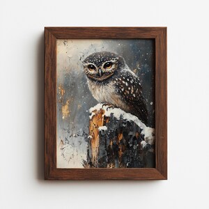 May include: A framed painting of an owl perched on a snow-covered tree stump. The owl has brown and white speckled feathers and large, expressive eyes. The artwork is set against a muted, textured background with hints of gold and gray.