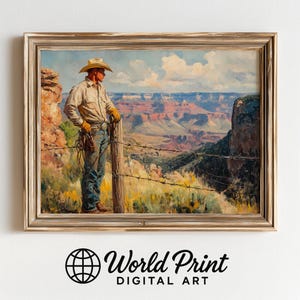May include: A framed print of a cowboy overlooking a canyon landscape. The cowboy wears a hat, shirt, jeans, and gloves, leaning against a fence. The background features a vast canyon with colorful rock formations under a blue sky.