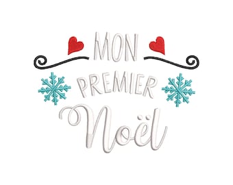 May include: White embroidered design with the text "MON PREMIER Noël" in a script font. The design includes red hearts, turquoise snowflakes, and black flourishes. The logo "BROD'ZILLA" is in the bottom right corner.