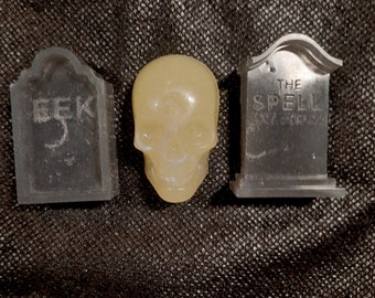 May include: Three Halloween-themed silicone molds: a skull, a tombstone that says "The Spell", and a tombstone that says "Seek".