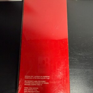 May include: A rectangular package with a bright red surface. The package has text in white, including the Isotoner trademark and company information. The package is sealed in clear plastic.