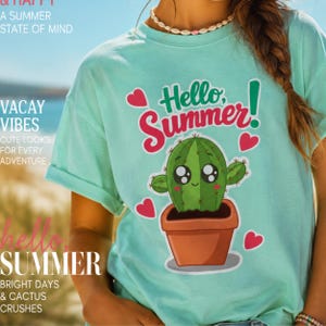 Puede incluir: Una camiseta de manga corta en color verde menta claro con un estampado gráfico de un cactus de dibujos animados sonriente en una maceta marrón. El texto "Hello, Summer!" aparece sobre el cactus en verde oscuro y rosa, rodeado de cuatro corazones rosas.