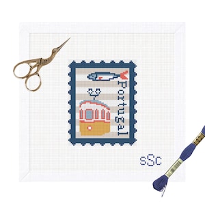 May include: A cross-stitch project featuring a postage stamp design with a tram and fish, labeled "Portugal." The design is on white fabric, with gold scissors and a blue thread spool nearby. The text "sSc" is also visible.