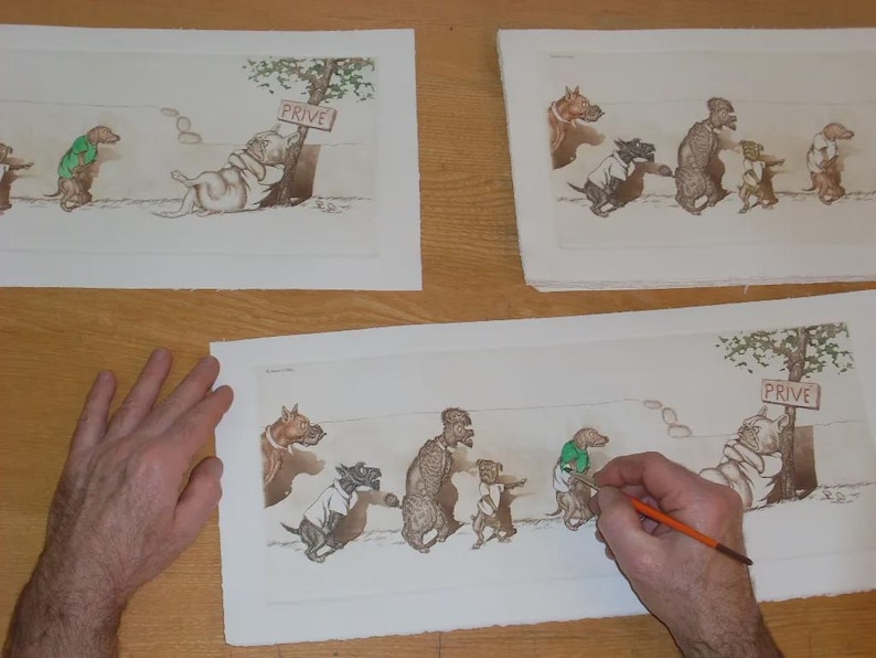 May include: Artwork of anthropomorphic dogs in various poses, some wearing clothes. One dog is leaning against a tree with a "PRIVE" sign. The artwork is on paper, with a person's hand holding a paintbrush, suggesting the art is being worked on.