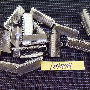 May include: A pile of 18mm silver metal slider buckles. The buckles have a textured surface and are designed to be used for straps or belts.