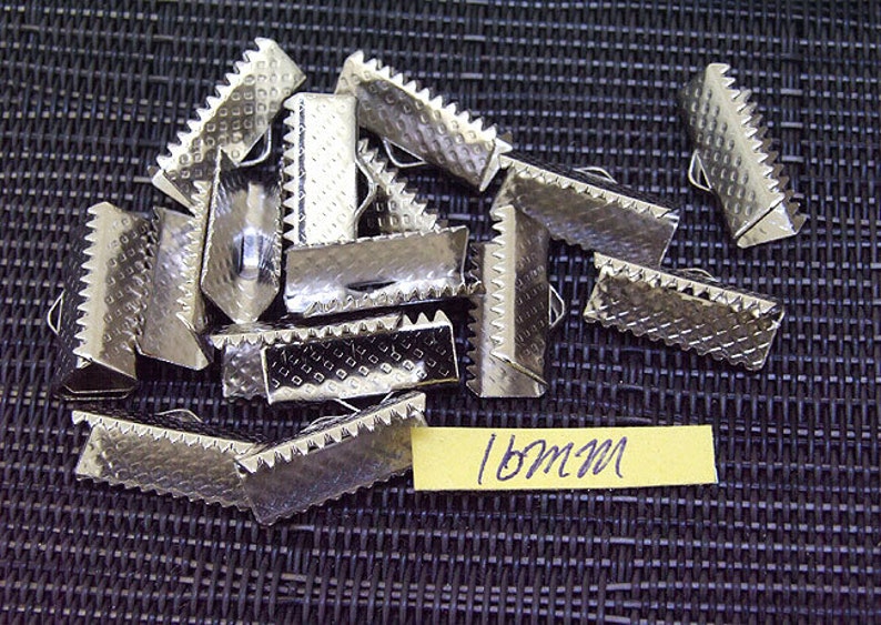 May include: A pile of 18mm silver metal slider buckles. The buckles have a textured surface and are designed to be used for straps or belts.