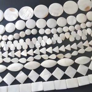 Puede incluir: Una colección de cuentas blancas de madreperla en varias formas y tamaños, incluyendo redondas, ovaladas, de lágrima, triangulares, cuadradas y rectangulares.