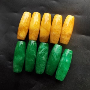 Op de afbeelding: Tien gepolijste edelsteen kralen. Vijf zijn goudgeel van kleur en vijf zijn diepgroen. De kralen zijn langwerpig van vorm, met afgeronde uiteinden. De edelstenen hebben een gladde, glanzende afwerking.