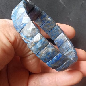 Op de afbeelding: Een blauwe en grijze lapis lazuli armband met vierkante kralen.