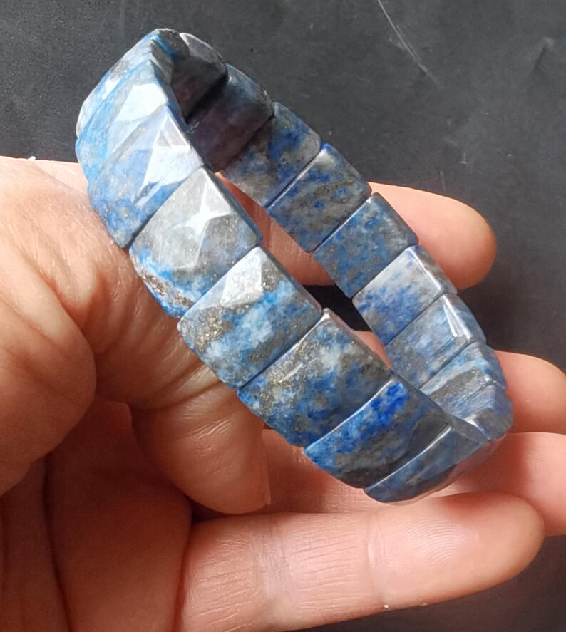 Op de afbeelding: Een blauwe en grijze lapis lazuli armband met vierkante kralen.