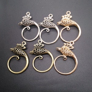 May include: Six ornate metal bird charms with open loops. The charms are in silver, gold, and bronze finishes.