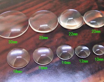 May include: Assortment of clear glass cabochons in various sizes, ranging from 10mm to 30mm. The cabochons are round and have a smooth, polished surface.