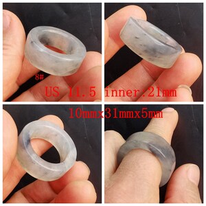 May include: A grey jade ring with a smooth, polished finish. The ring is 10mm wide, 31mm long, and 5mm thick. The inner diameter of the ring is 21mm, which corresponds to a UK size N.