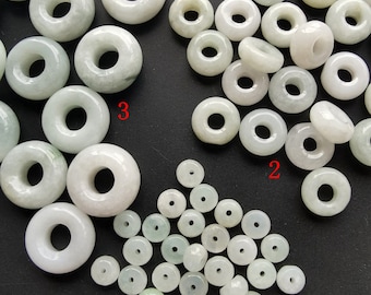 May include: Three groups of white jade donut beads. The first group has 30 beads, the second group has 20 beads, and the third group has 10 beads.