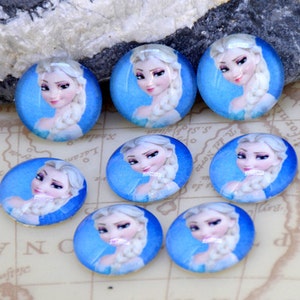 May include: Ten round, glass cabochons featuring a cartoon image of a young woman with long, blonde hair. The woman is wearing a blue dress and has a light blue background.