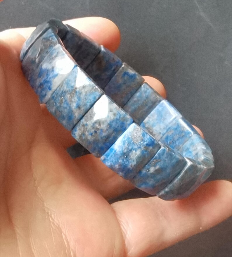 Op de afbeelding: Een blauwe en witte lapis lazuli armband met vierkante kralen.