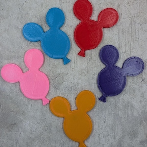 May include: A collection of five colorful, 3D-printed balloon-shaped objects. The balloons are in shades of blue, red, pink, purple, and orange. The objects have a textured surface and a small, rounded tail.