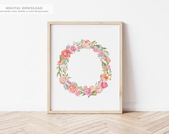 May include: A framed watercolour print of a floral wreath. The wreath features pink, peach, and yellow roses, with green leaves and blue accents. The frame is light wood. Text at the top reads "DIGITAL DOWNLOAD".