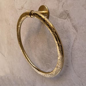 Pu&ograve; includere: Un portasciugamani color oro con un ornato disegno floreale inciso. L'anello &egrave; circolare e montato su una base rotonda. L'apparecchio &egrave; in metallo ed &egrave; progettato per essere montato a parete.