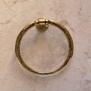 Pu&ograve; includere: Un portasciugamani dorato con un motivo floreale inciso e ornato. L'anello &egrave; circolare e fissato a un supporto a parete circolare. Il design &egrave; vintage e decorativo, adatto a un bagno.