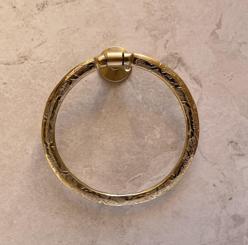Pu&ograve; includere: Un portasciugamani dorato con un motivo floreale inciso e ornato. L'anello &egrave; circolare e fissato a un supporto a parete circolare. Il design &egrave; vintage e decorativo, adatto a un bagno.