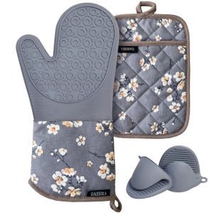 May include: A gray silicone oven mitt and pot holder set with a floral pattern. The mitt has a textured grip, and the pot holder is quilted. Two small gray silicone pinch mitts are also included. The brand name "DASSIRA" is visible.