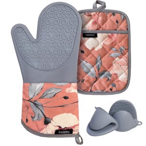 May include: A gray silicone oven mitt and pot holder set with a floral design in pink, gray, and white. The set includes two small gray silicone pinch mitts. The brand name "DASSIRA" is visible on the pot holder and oven mitt.
