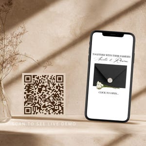 May include: A smartphone displaying a digital wedding invitation with the text Together with their families Amelie & Rowan and Click to open above a black envelope with a wax seal and white flowers, next to a square QR code for a live demo.