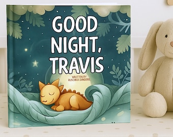 May include: A children's book titled "Good Night, Travis" with a sleeping cartoon dragon illustration. The cover features a night sky background with the author's name. A stuffed bunny is next to the book.