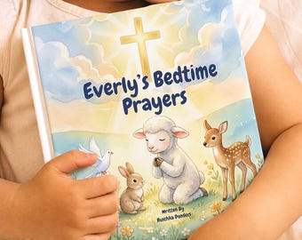 May include: A hardcover book titled Everly's Bedtime Prayers with a watercolor illustration featuring a glowing cross in the sky, a white lamb praying, a small brown rabbit, a white dove, and a spotted fawn in a grassy field with flowers.