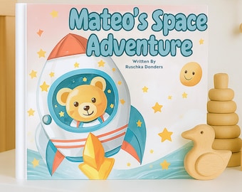 May include: A children's book titled "Mateo's Space Adventure" features a rocket ship with a teddy bear pilot. The cover is decorated with stars and a smiling yellow planet. A wooden duck and stacking rings are also visible.