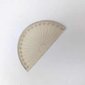 May include: A clear, semi-circular plastic protractor featuring black printed degree markings along the curved edge. The tool displays two rows of numbers ranging from 0 to 180 degrees, allowing for precise angle measurements in geometry tasks.